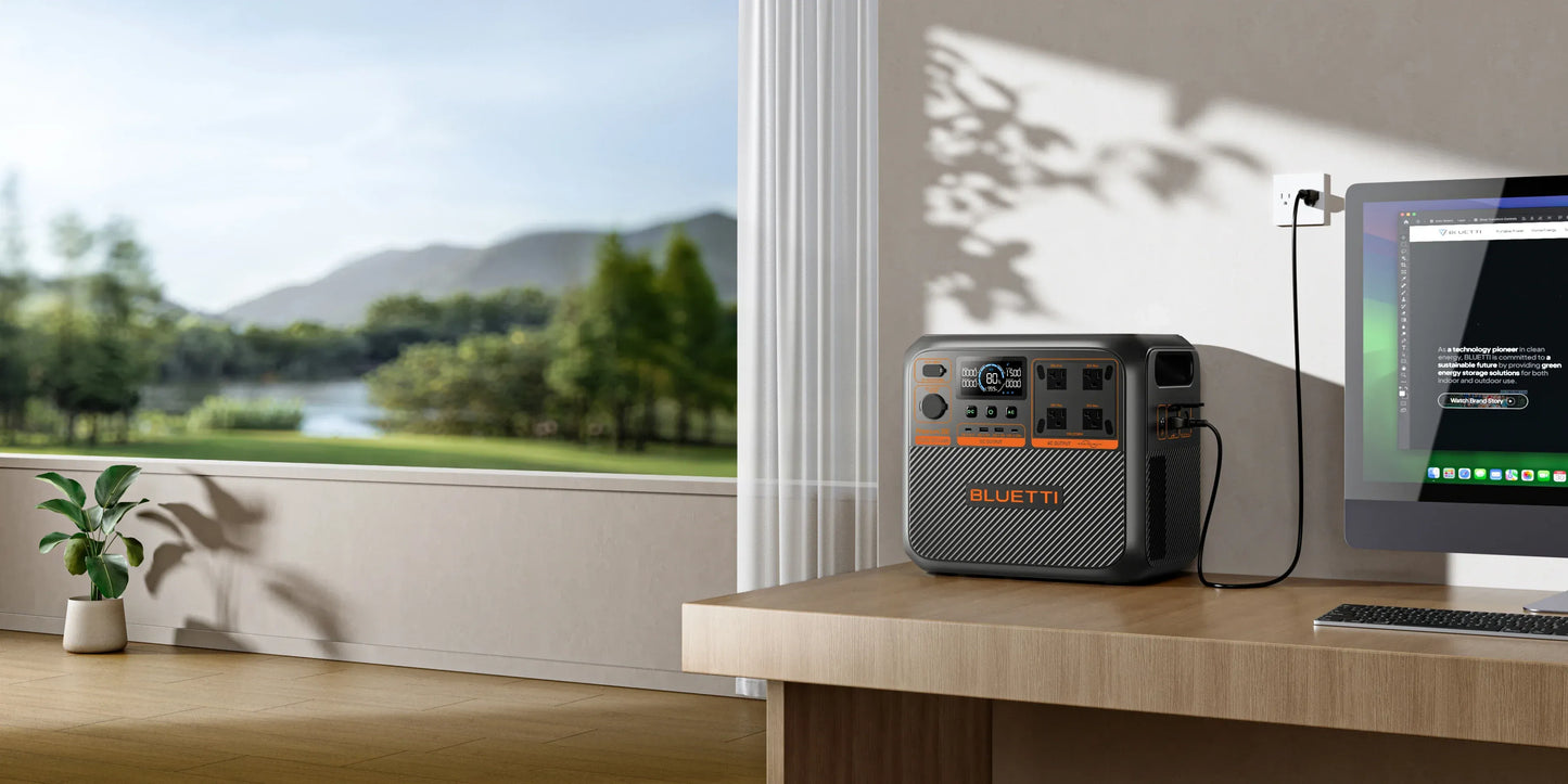 BLUETTI Premium 200 V2 Portable power station charging a computer on a desk with a scenic view outside.
