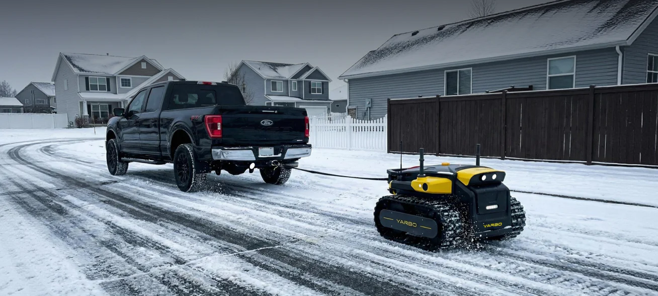 Yarbo Core operating on a snow-covered driveway