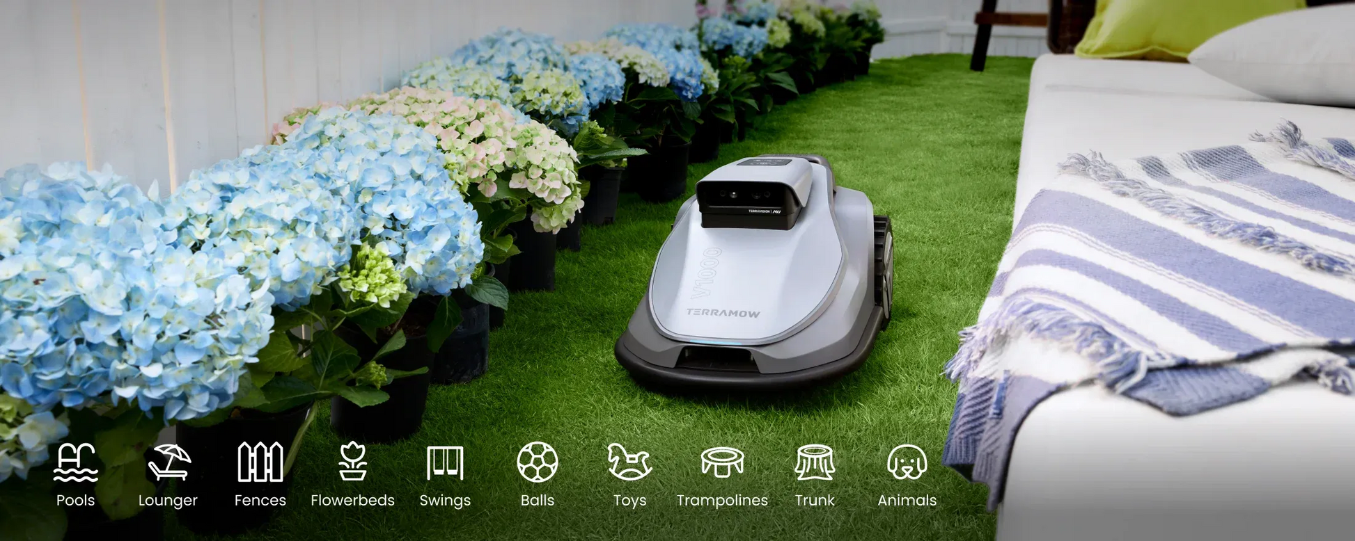 TerraMow V1000 robot lawn mower navigating a landscaped garden with flowers and outdoor furniture