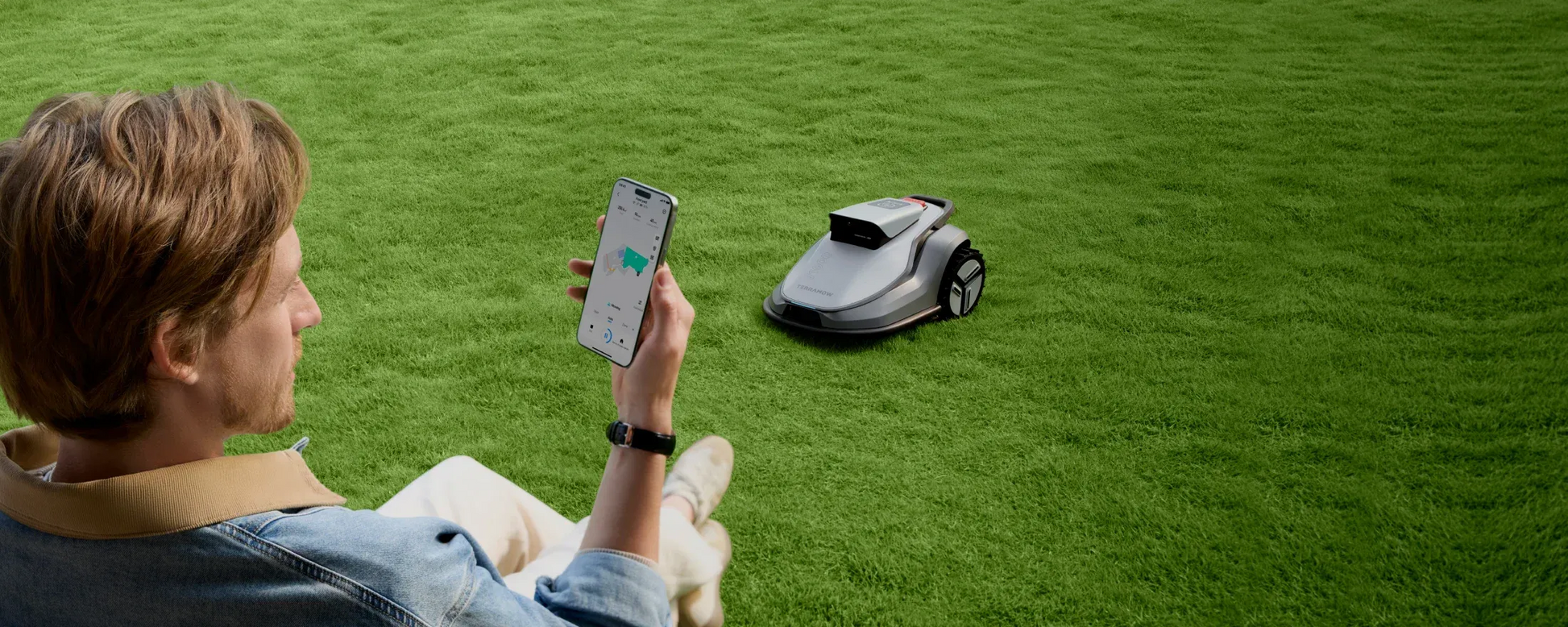 Person using the TerraMow mobile app to control the V1000 robot lawn mower